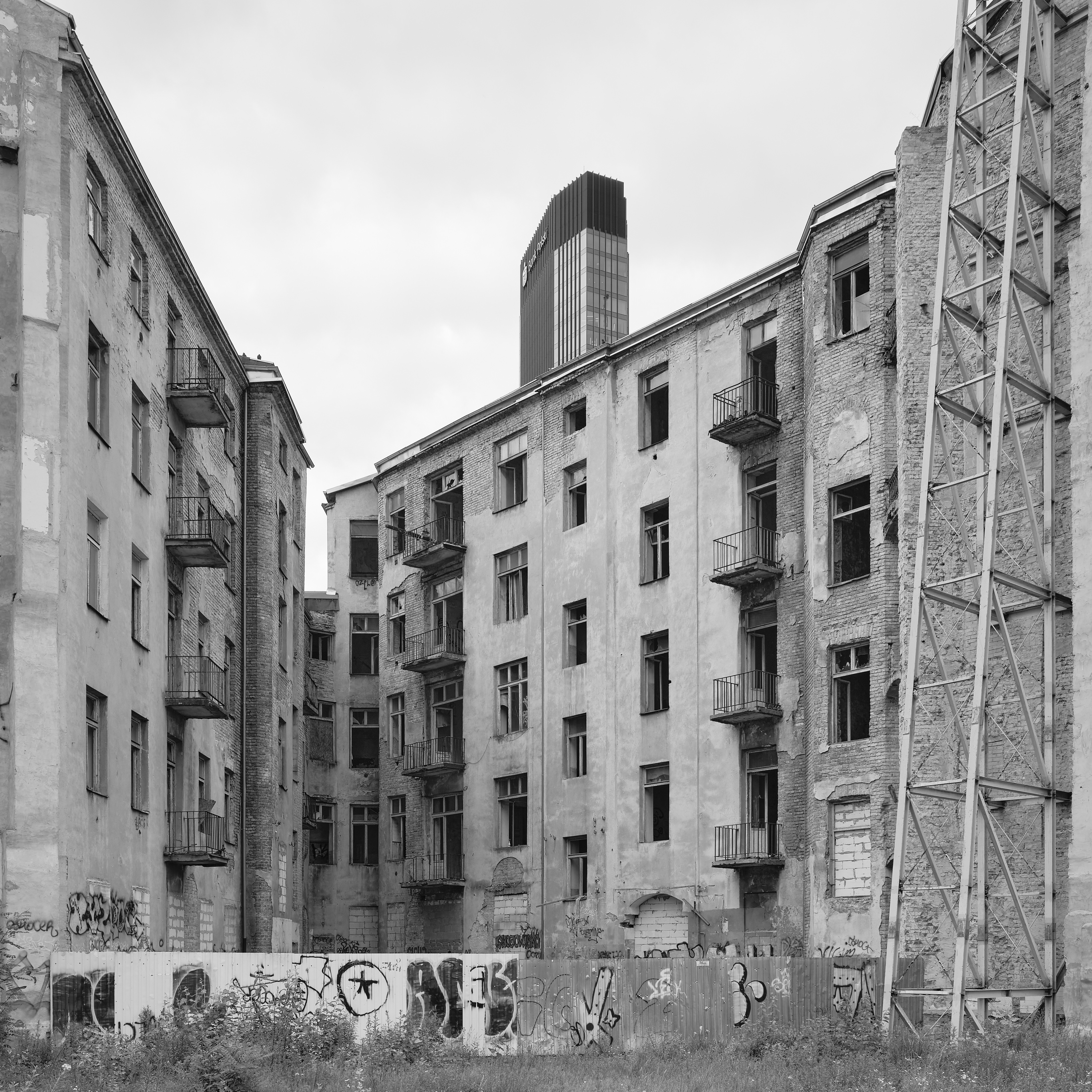 Verlassene graue Wohnblocks ohne Personen, düster, mit Graffiti und Turm