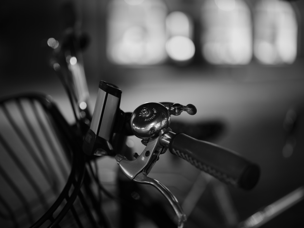 Schwarzweisser Fahrradlenker mit Klingel und Handyhalter im Nachtlicht