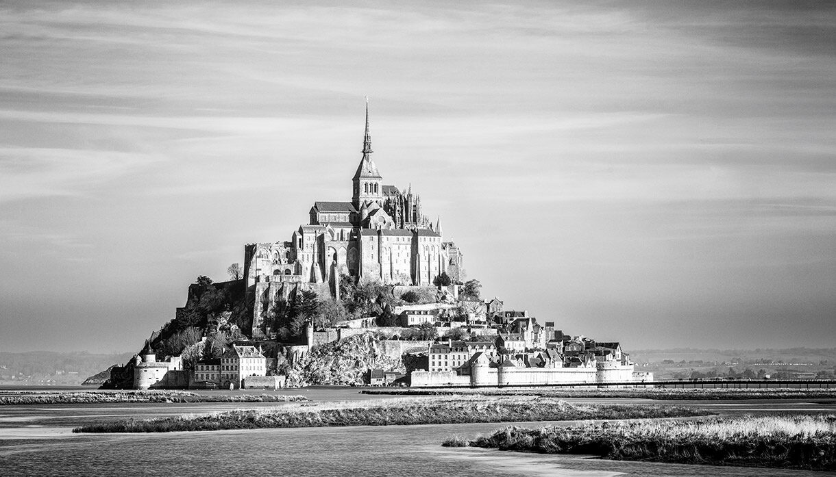 Schwarzweissaufnahme des Mont Saint Michel mit Abtei auf einer Felseninsel